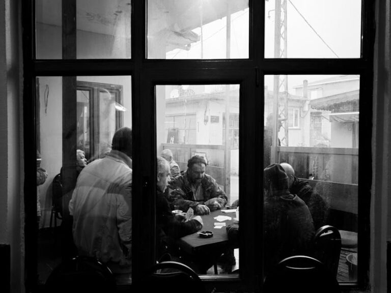 Men playing cards in a cozy Istanbul cafe, captured in black and white.