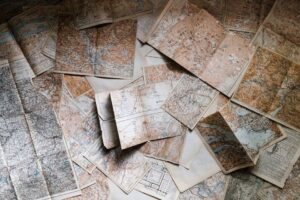 A collection of vintage maps scattered for exploring world journeys and discoveries.
