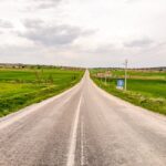 Empty Country Road Through Green Fields | Rural Landscape Perspective