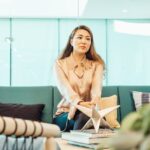 Professional woman sitting on a sofa in a contemporary office setting, conveying calm and focus.