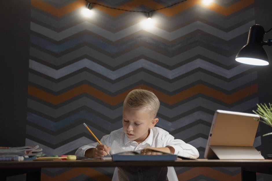 A young boy focused on homework under a lamp light in a cozy room.