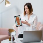 Professional woman explaining facial anatomy using a digital tablet in a modern office setting.