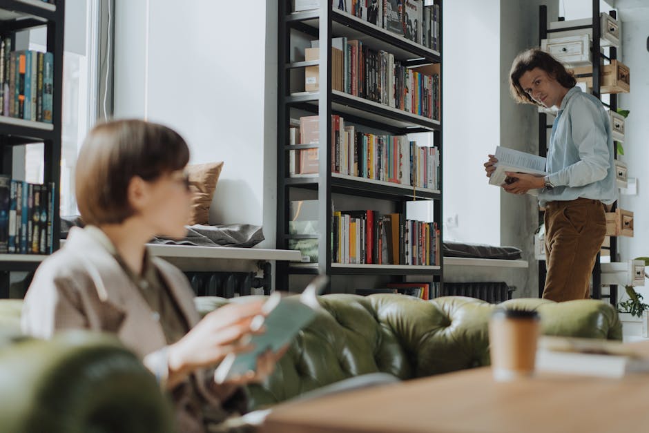 Young adults reading in a modern library with bookshelves, creating a cozy intellectual atmosphere.