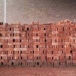 A pile of stacked red bricks at a construction site in Bangladesh, showcasing brick patterns and industrial textures.