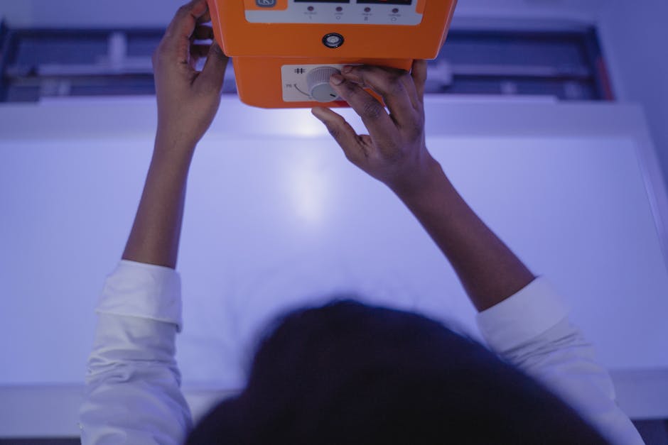 A medical professional adjusting an X-ray machine in a clinic setting.