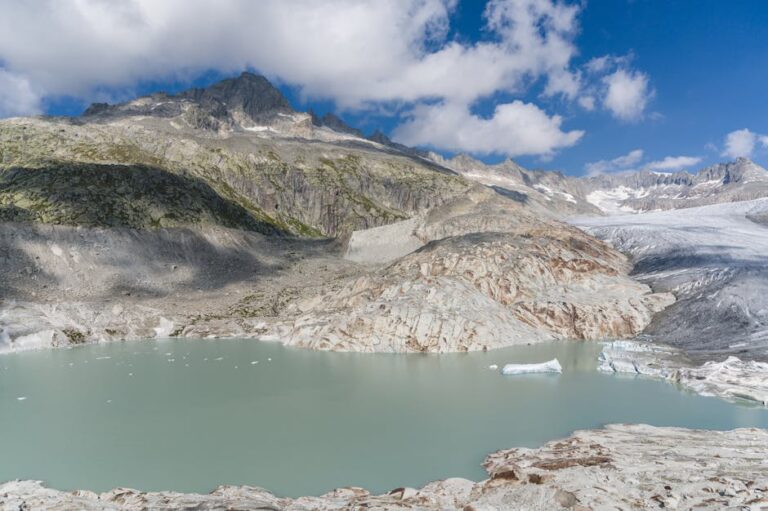 Captivating landscape of the Rhône Glacier and serene turquoise lake in Swiss Alps.