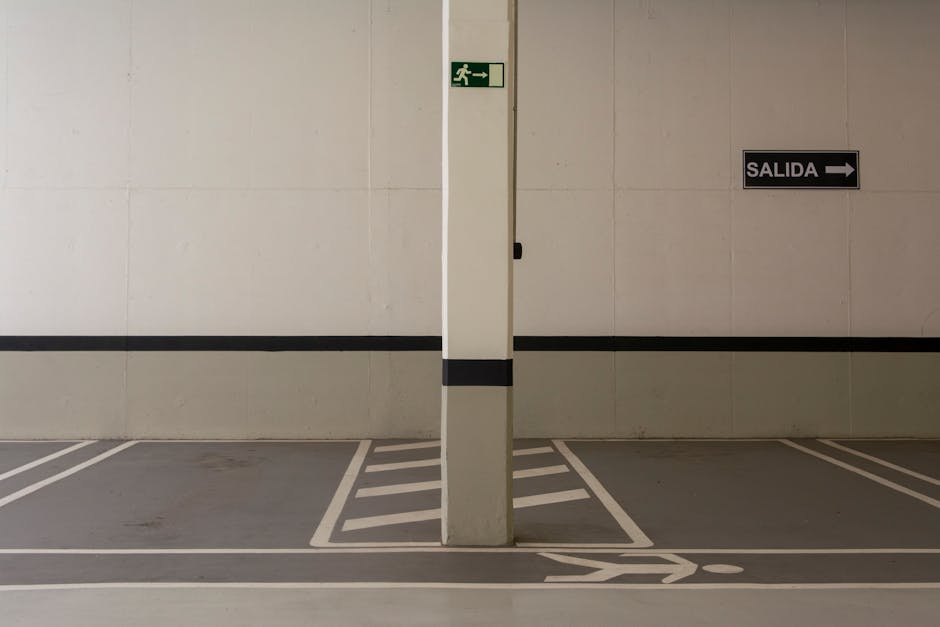 Minimalist underground parking area with exit signs and marked pathways.