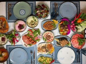 A colorful spread of Middle Eastern dishes including hummus, salads, and grilled vegetables, perfect for a festive gathering.