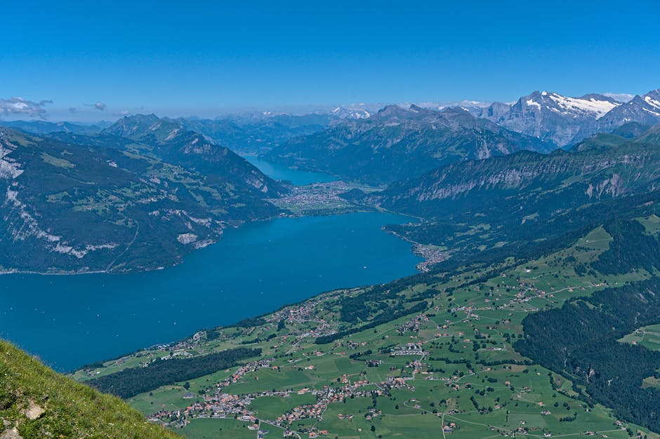 Stunning aerial view of Thun Lake and Swiss Alps, capturing lush valleys and majestic mountains.