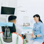Dentist interacting with patient in a bright, modern dental clinic.